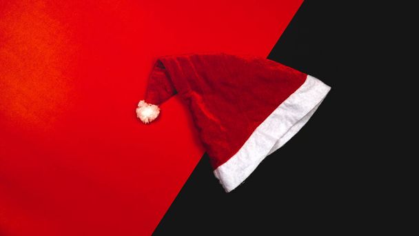 Joulun tausta käsite. Top näkymä joululahja laatikko kuusen oksat ja joulupukin hattu punaisella taustalla. - Valokuva, kuva