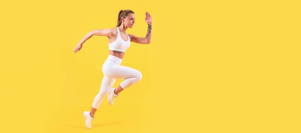chica de fitness corredor corriendo en ropa deportiva sobre fondo amarillo. Mujer saltando corriendo banner con simulacro de copyspace - Foto, Imagen