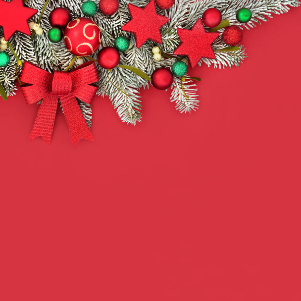 Різдвяний святковий фон межує з оздобленням дерев та зимовим фіром і снігом на червоному тлі. Яскрава композиція для Xmas і новорічні канікули. - Фото, зображення