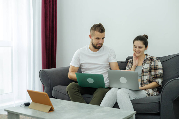 Couple at home doing online shopping with laptop - Photo, Image