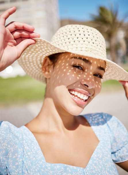 Happy, summer and a woman on holiday with hat and smile on face in the sun. Nature, sunshine and relax, girl outdoors on a tropical vacation, weekend away or time for freedom and fun in sunny weather. - Photo, Image