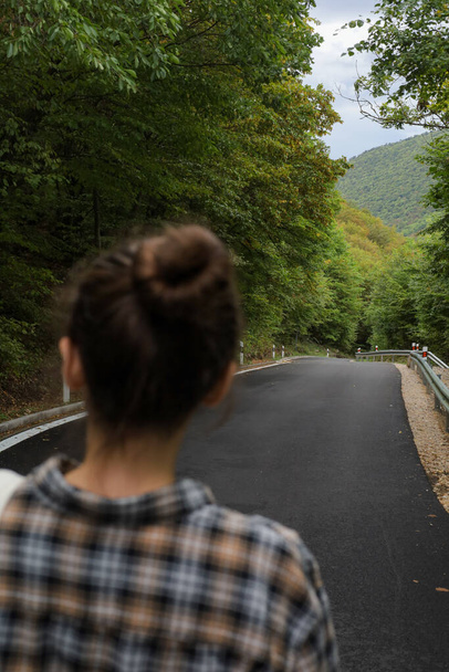 kaunis tyttö kävelee metsässä lähellä tietä - Valokuva, kuva