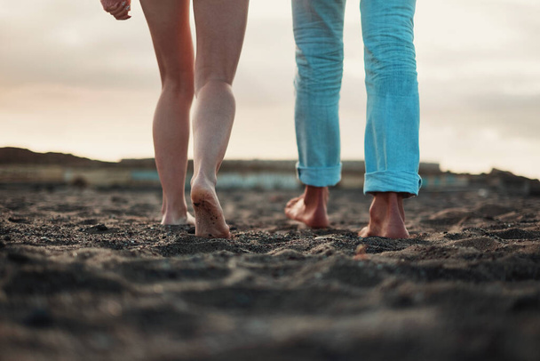 Close up and legs view of man and woman walking together on the ground in barefoot natural style. Concept of love and life together. Nudism. A couple of people walk. Sky in background. Travel. - Photo, Image