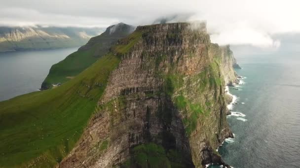 Uitzicht op Kalsoy eiland, Faeröer. Verbazingwekkende Faeröer natuur, groene heuvels en prachtige rotsachtige kliffen en bergen. Kallur vuurtoren. Zonnige dag in de zomer. Film in Faroe. 4k-beelden - Video