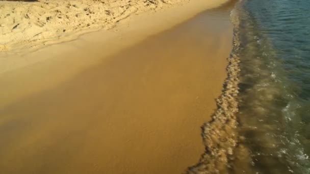 Nahaufnahme des türkisfarbenen Sandstrandes mit klarem Wasser von Mylopotas auf Ios Griechenland - Filmmaterial, Video