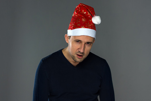 Imagem do homem sério adulto em chapéu de Natal
 - Foto, Imagem