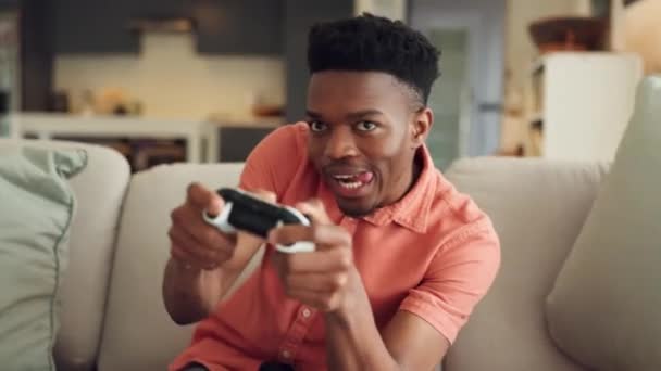 Jogos online, streaming e homem negro jogando um jogo de vídeo enquanto relaxa em sua sala de estar. Entretenimento, tv e controlador de um jogador africano com energia e liberdade sentado no sofá em casa. - Filmagem, Vídeo