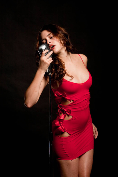 Beautiful singer singing with a retro microphone - Fotoğraf, Görsel