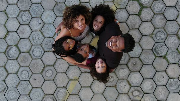 Black family hugging each other in circle together looking up - Фото, зображення