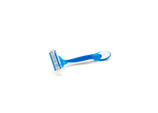 Una sola máquina de afeitar desechable de plástico azul y blanco con mango ergonómico aislado sobre fondo blanco. Afeitadora afilada con cuchillas de acero y cubierta. - Foto, imagen