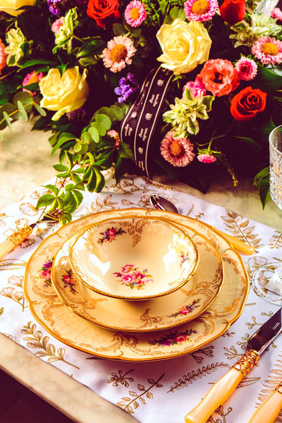 beautiful plate and fresh perfect colorful flowers standing on luxury table - Fotó, kép