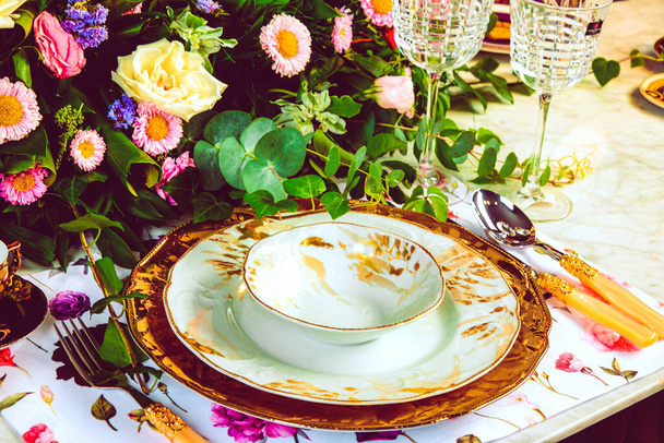 beautiful plate and fresh perfect colorful flowers standing on luxury table - Foto, Imagen