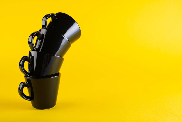 Black cups on a jolly background. tower of cups. Minimalism - 写真・画像