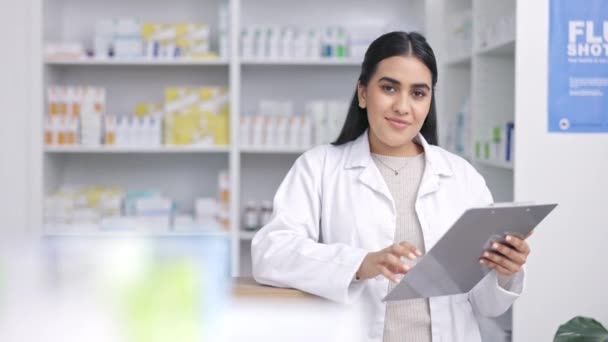 Pharmacy woman and medicine inventory portrait with drugstore pills record and a smile. Pharmaceutical professional at dispensary counter busy checking medical product data on clipboard - Footage, Video