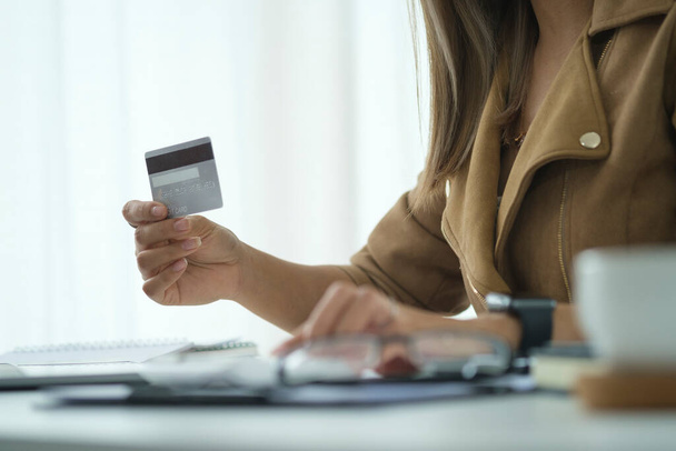 Happy woman holding credit card in her hand. Online shopping, e-commerce concept.	 - Foto, imagen