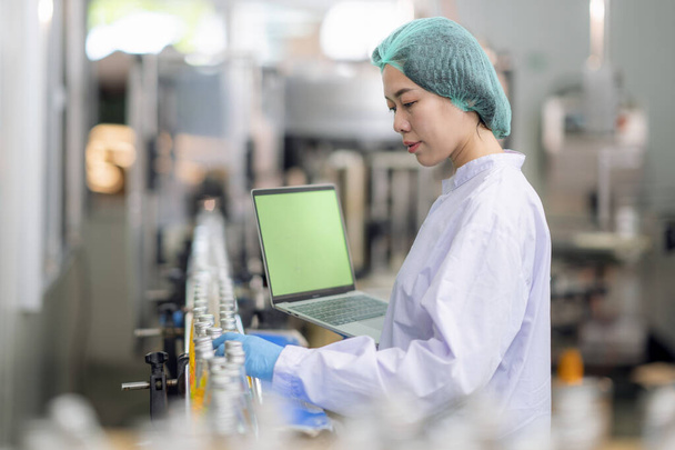 Asiatischer professioneller Lebensmittelwissenschaftler überprüft und kontrolliert die Qualität von Getränken im chemischen Labor in der Fabrik zur Lebensmittelinduktion - Foto, Bild