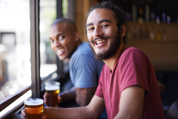 Jó nevetés egy jó sör mellett. Egy levágott kép barátokról, akik egy bárban söröznek. - Fotó, kép