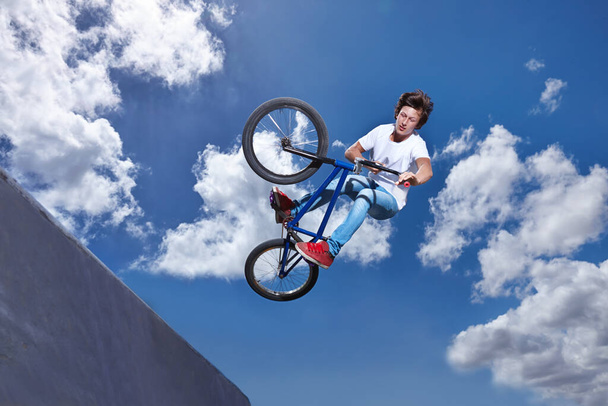Practicing for the x games. Full length shot of a teenage boy riding a BMX at a skatepark - Photo, Image