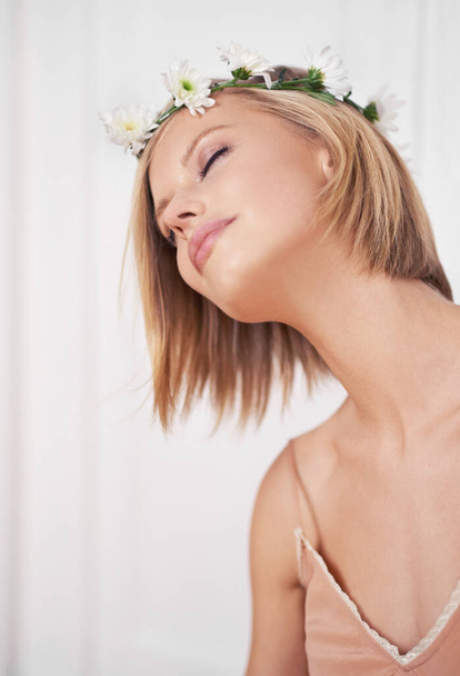 Lost in a beautiful daydream. A cropped shot of a beautiful young woman wearing a flower crown - Photo, Image