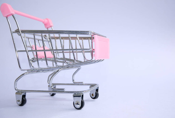 carro de la compra vacío detalles de plástico rosa sobre un fondo claro - Foto, imagen