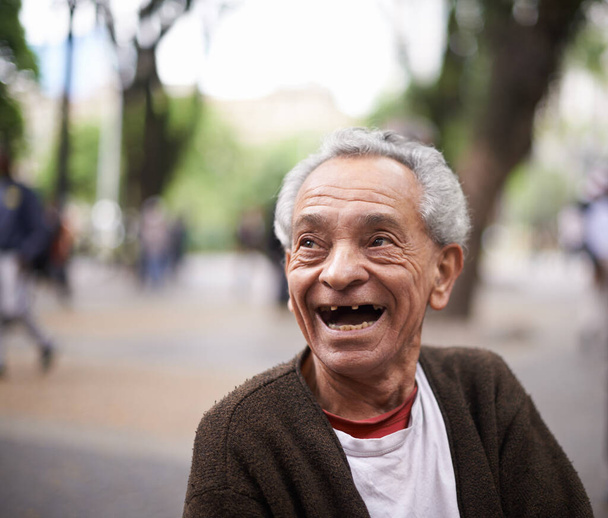 Hes lived quite the life. smiling old man sitting outside - Фото, изображение