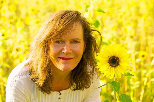 Capturing a radiant and attractive brunette lady enjoying a mindful moment in a sunflower field. - Photo, Image