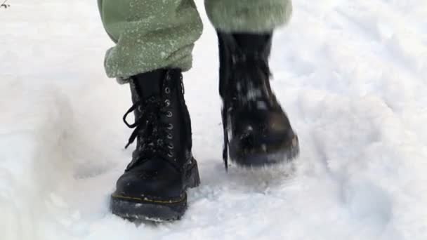 Vista frontal de un hombre de pie congelado en botas negras en invierno. El lapso de tiempo de sacudir la nieve de las botas en invierno en la entrada de la casa. Sacudiendo la nieve de los zapatos, nevadas fuertes en invierno. - Imágenes, Vídeo