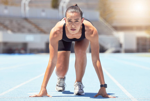 Woman runner start position on race track, competition or cardio for healthy exercise, workout and fitness in stadium. Focus young female sports athlete ready in running challenge, speed and marathon. - Foto, Imagem