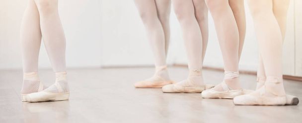 Ballet, leader and dancer group feet in dance studio training in artist academy with white wall and floor. Women team, class or students dancing on pointe shoes for school performance with lens flare. - Foto, Imagem