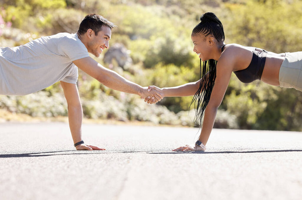 Motivation, fitness and handshake by exercise partnership deal with athletic couple shaking hands in workout challenge outdoors. Friends, hands and pushup fun with sports, bonding and competitive. - Photo, Image