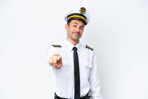 Piloto de avión sobre fondo blanco aislado apunta con el dedo a usted con una expresión de confianza - Foto, Imagen