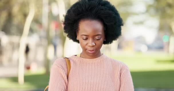 Porträt einer jungen, entspannten schwarzen Frau mit Afro an einem sonnigen Tag im Freien. Ein afroamerikanischer Influencer oder Student, der fröhlich, glücklich und selbstbewusst nach außen wirkt und Lächeln, Lachen und Magie für schwarze Mädchen zeigt - Filmmaterial, Video