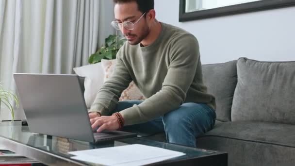 Ember, a szemüveg és a laptop kanapén dolgoznak a nappaliban, és e-mailt írnak üzleti ötletek miatt otthon. Okos férfi szabadúszó vagy gépíró középpontjában a munka számítógép ül a kanapé tervezés ötletek. - Felvétel, videó