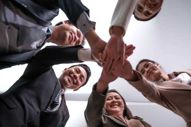 Üzletemberek csoportja, akik egymás kezét fogva állnak a találkozás után. - Fotó, kép