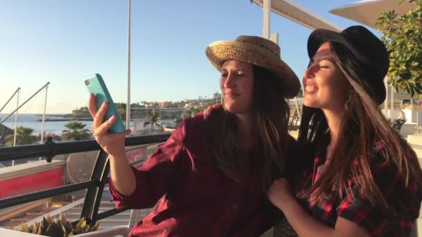 En iyi iki kız arkadaş sosyal ağlarda selfie çekiyor. Yaz mevsimindeler ve deniz kenarındalar. - Video, Çekim