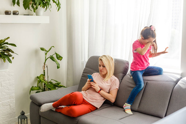 Mãe confortando sua filha adolescente em casa no sofá
 - Foto, Imagem