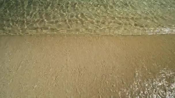 Nahaufnahme des türkisfarbenen Sandstrandes mit klarem Wasser von Magganari auf Ios Griechenland - Filmmaterial, Video