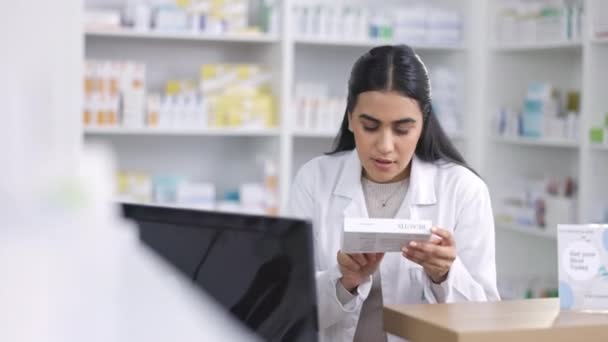 Apotheker werkt op de computer bij een apotheek met pillen om de bestelling online te controleren. Vrouw met technologie om toegang te krijgen tot medische database, inventariscontrole en online medisch voorschrift in een gezondheidswinkel. - Video