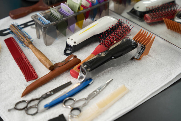 No people photo of different kinds of hair combs and hair-cutting tools displayed on clean white towel - Φωτογραφία, εικόνα