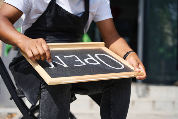 Primer plano de las manos escribiendo la palabra Abrir en un letrero - Foto, Imagen