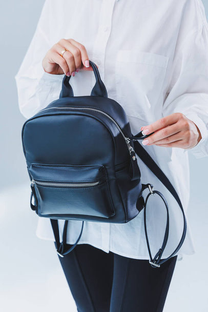 Black leather backpack in a woman's hand. A man with a luxurious leather backpack. Women's bags - Foto, Bild