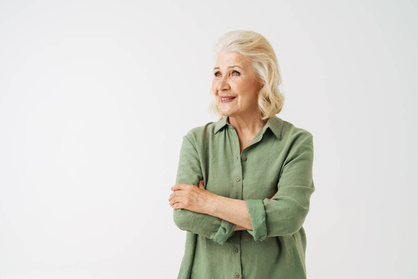 Grey senior woman in shirt smiling and looking aside isolated over white background - Photo, Image