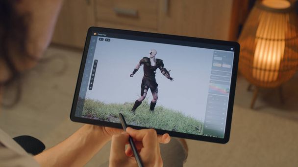 Mužský 3D designér vytvářející 3D animaci postavy videohry v designové aplikaci na moderním digitálním tabletu pomocí stylus - Fotografie, Obrázek