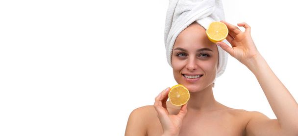 vrolijk jong vrouw met een glimlach op haar gezicht na een douche houdt een gesneden oranje in haar handen. - Foto, afbeelding