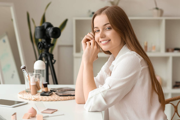 Блогер жіночої краси сидить за столом у роздягальні
 - Фото, зображення