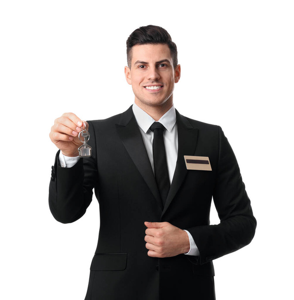 Happy receptionist in uniform holding key on white background - Foto, afbeelding