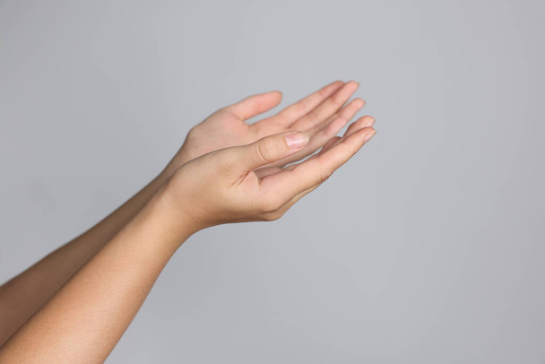 Woman stretching hands against light grey background, closeup. Space for text - Photo, Image