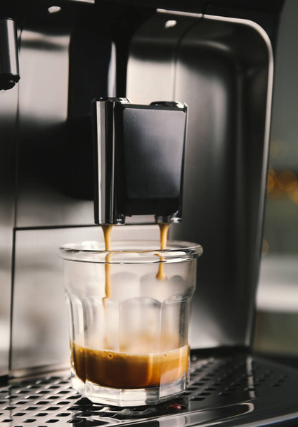 Espresso kone kaatamalla kahvia lasiin, lähikuva - Valokuva, kuva
