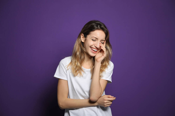 Cheerful young woman laughing on violet background - Fotografie, Obrázek