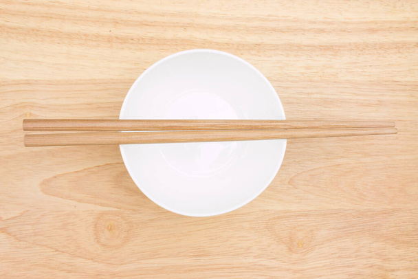 chopsticks and bowl on wooden board - Фото, зображення